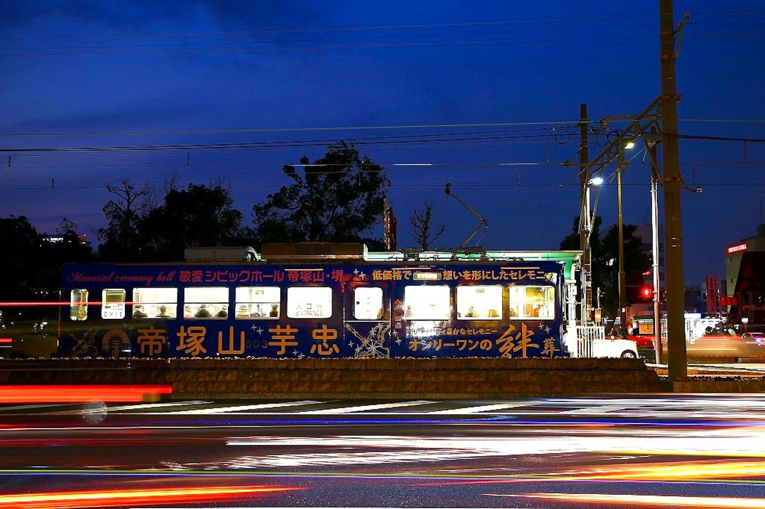 夜間照亮的藍色電車和光跡
