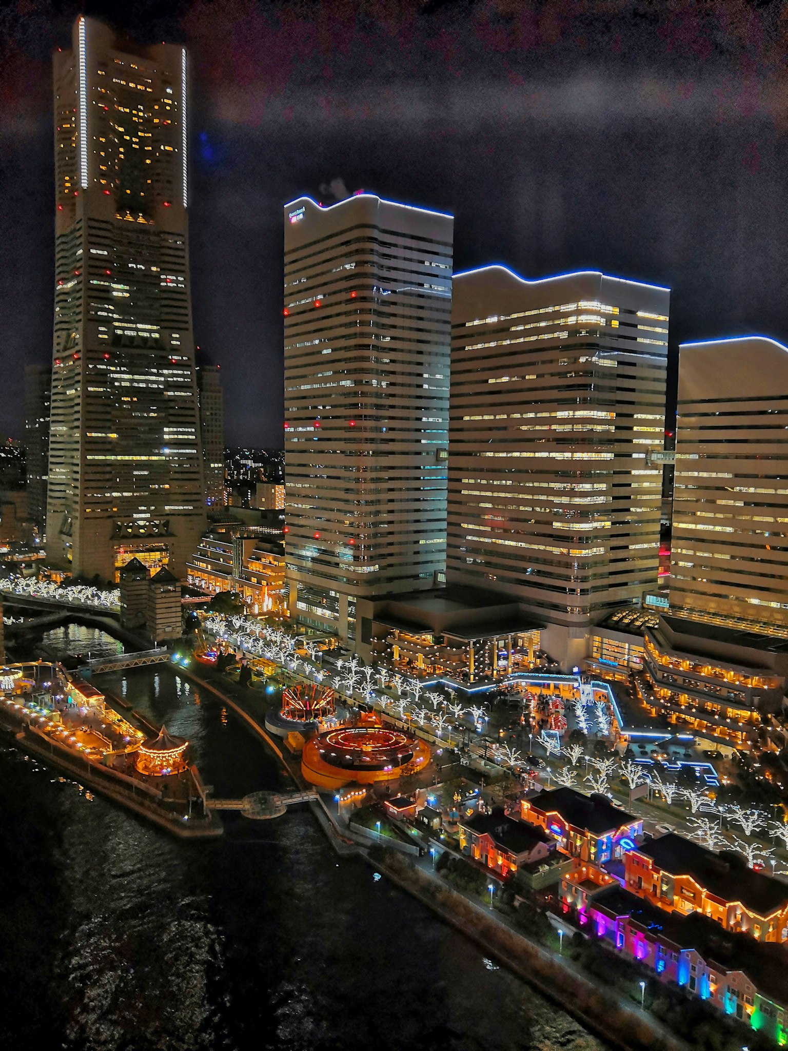 Vista notturna di Yokohama con grattacieli e fiume illuminato