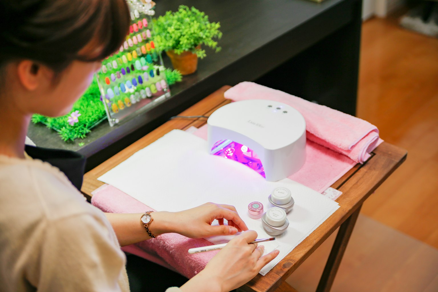 Frau, die Nagelkunst mit einer Gel-Nagellampe genießt
