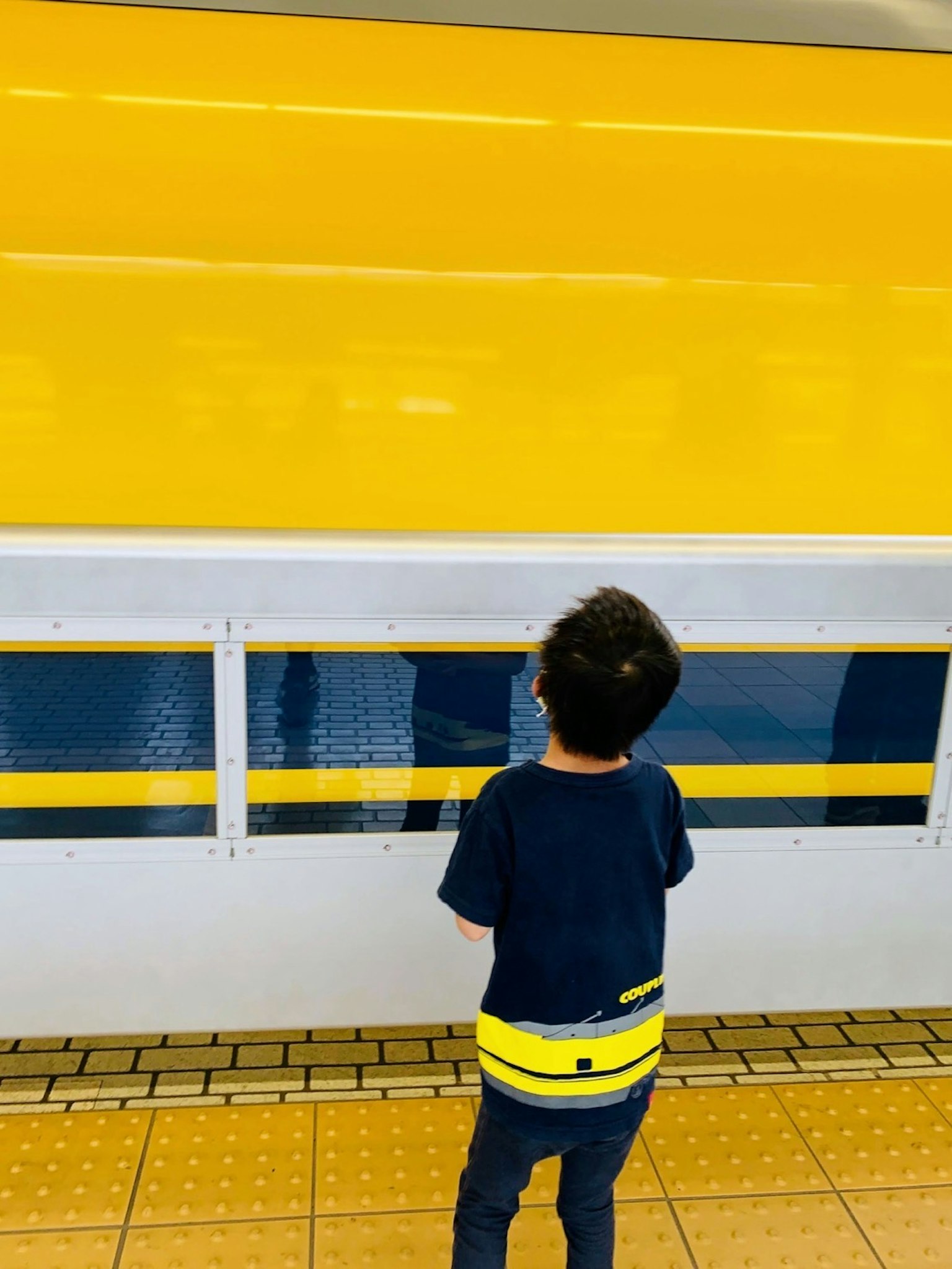 Child gazing at a bright yellow wall