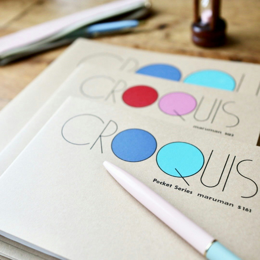 desk scene with colorful circular stationery and a pen