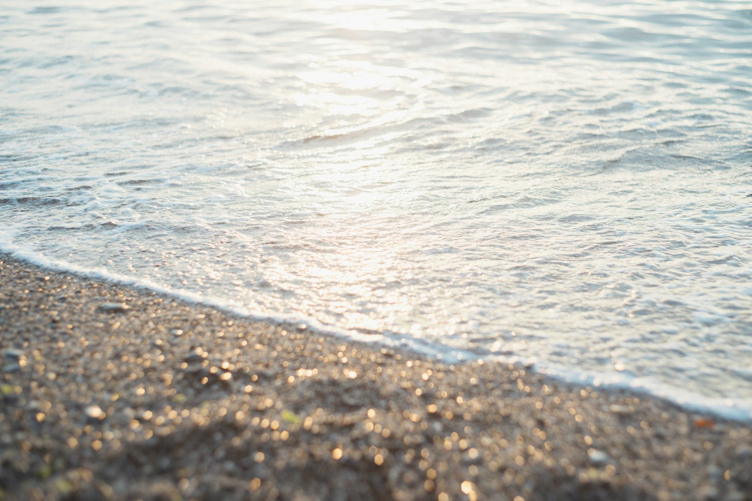 Sanfte Wellen brechen an einem Sandstrand