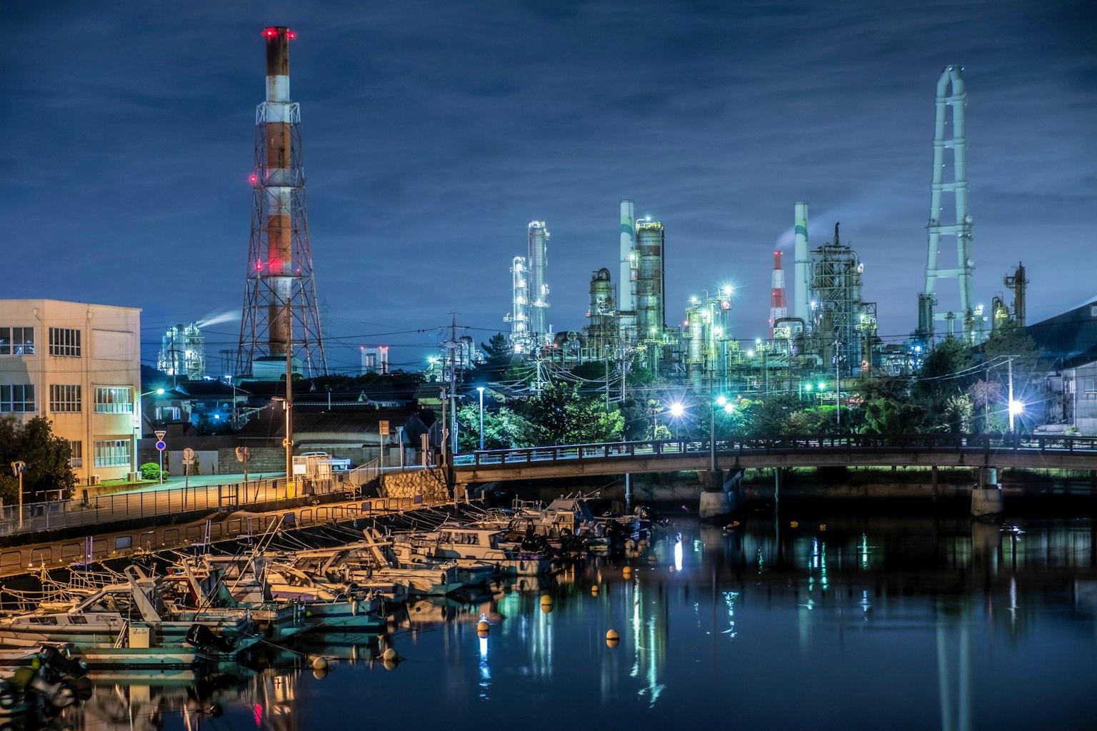 Vista notturna di un'area industriale con fabbriche e camini illuminati