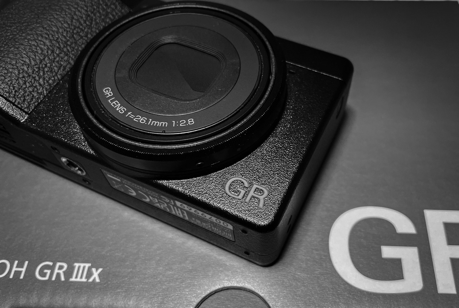 Close-up image of Ricoh GR IIIx camera featuring a black body and lens