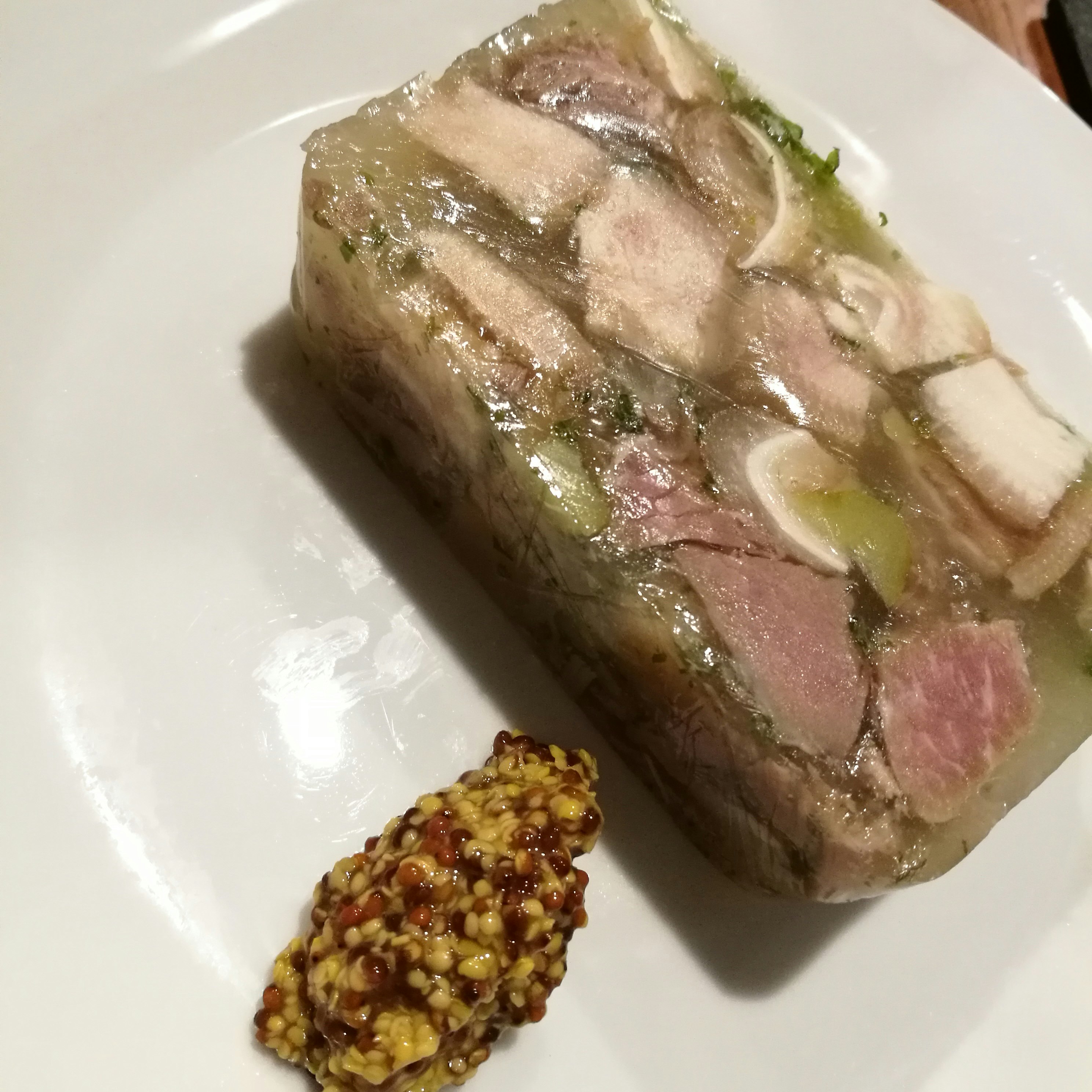 白盤上的肉凍與顆粒醬