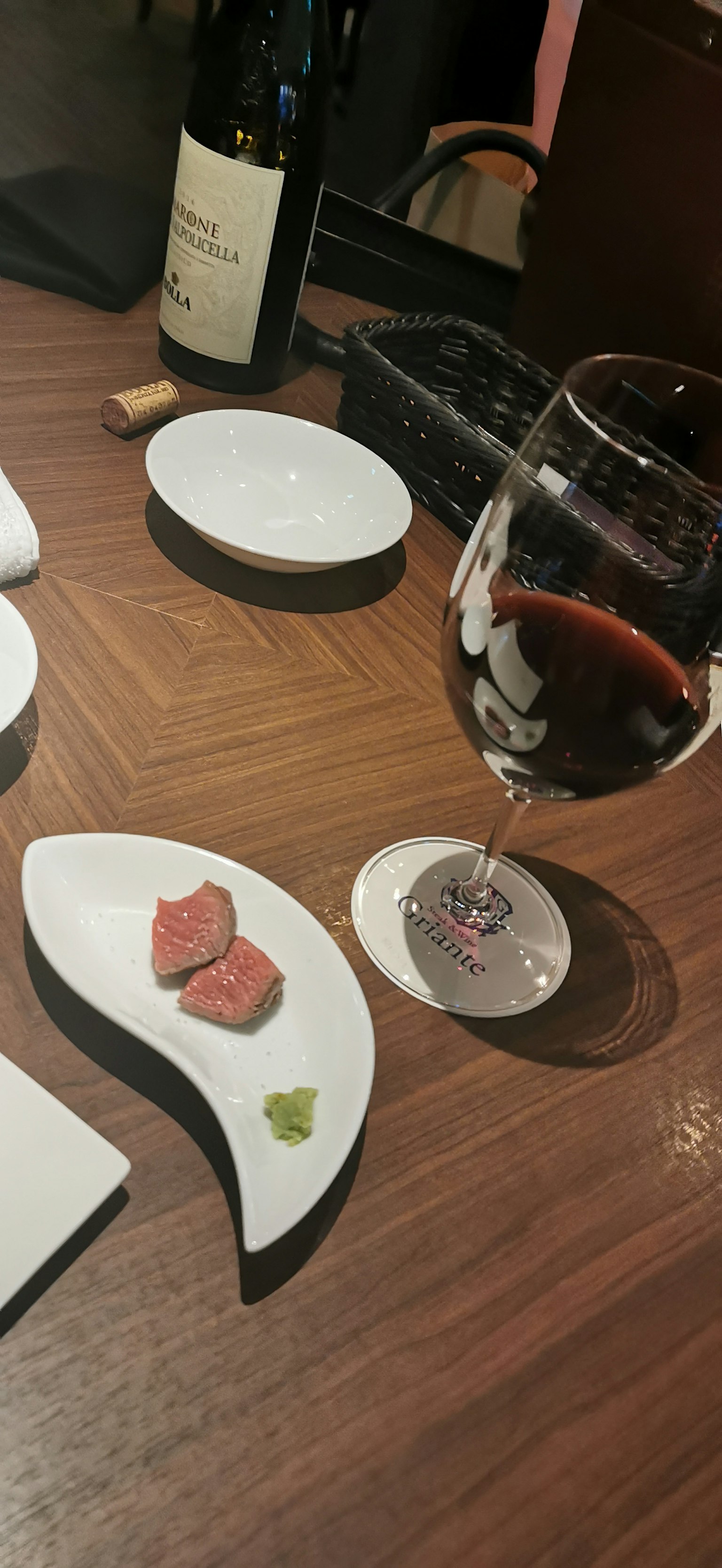 Ein Glas Rotwein mit einem kleinen Teller Essen auf einem Holztisch