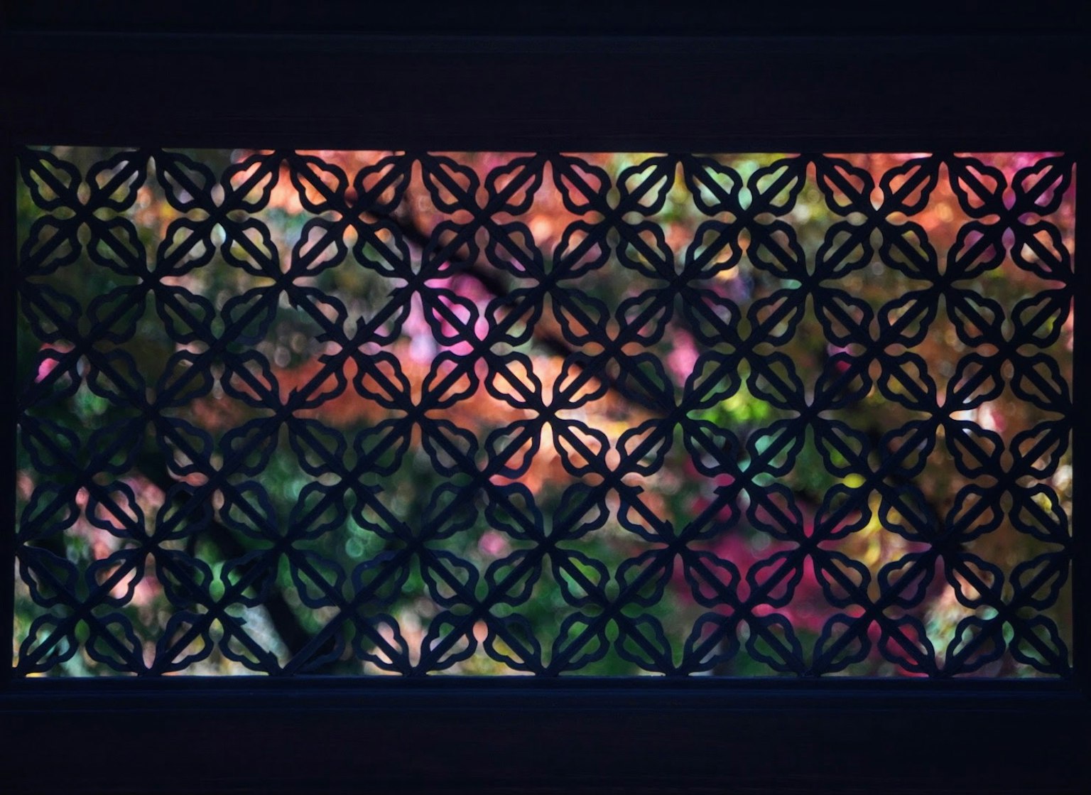 Griglia decorativa di una finestra con luce colorata che filtra
