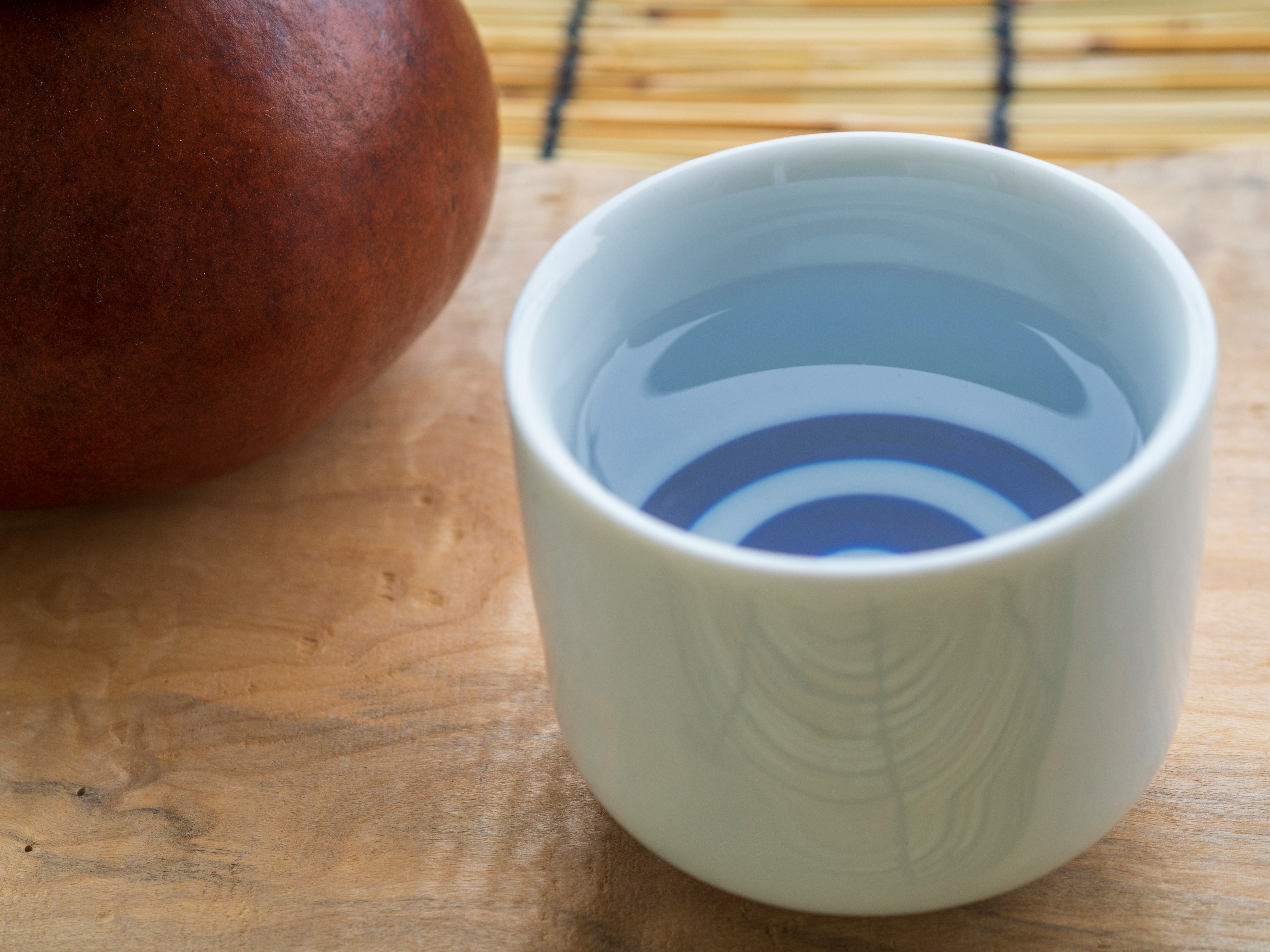 木板上的茶杯和棕色茶壺