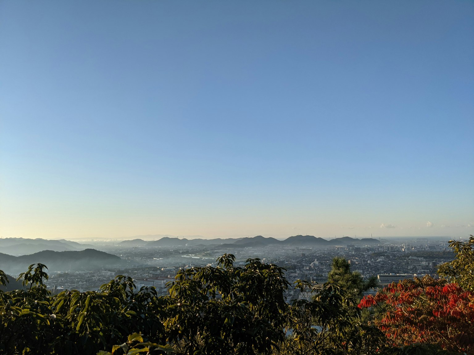 Ciel bleu clair avec montagnes lointaines et vue sur la ville