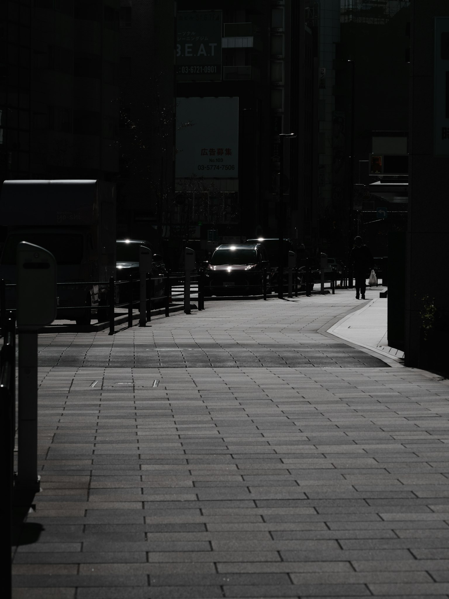 Scène urbaine faiblement éclairée avec des voitures sur un trottoir