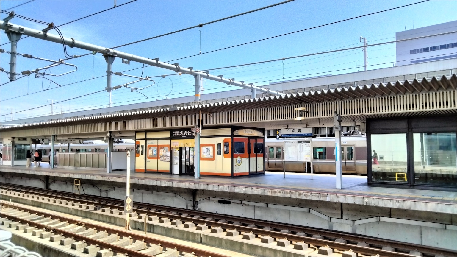 Bahnhof Plattform mit einem orangefarbenen Zug unter blauem Himmel