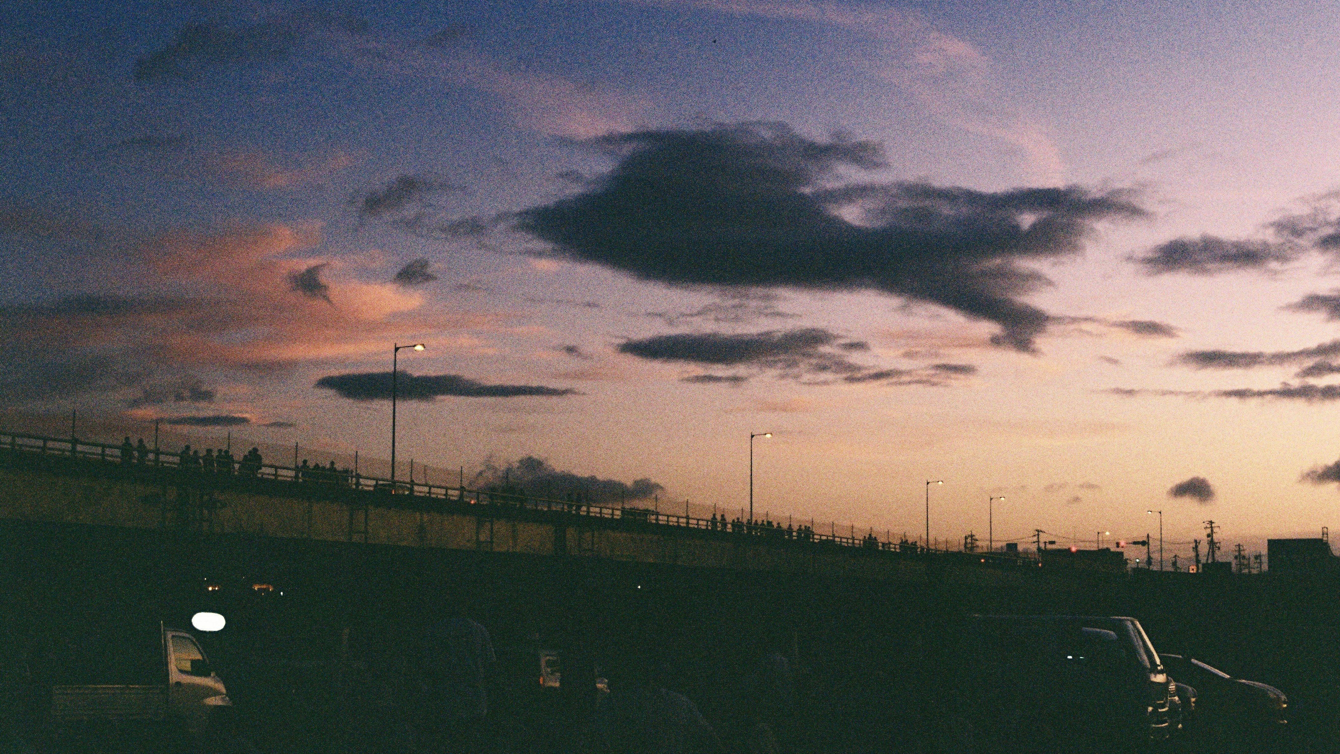 夕暮れの空と雲のむこうに広がる田園の風景