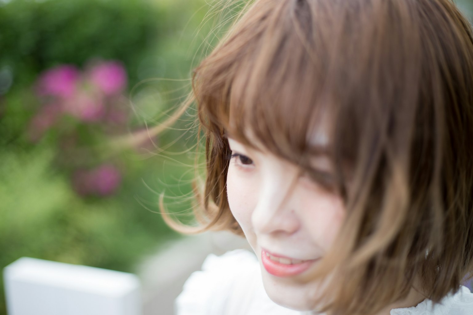 Joven mujer sonriendo con el cabello al viento al aire libre