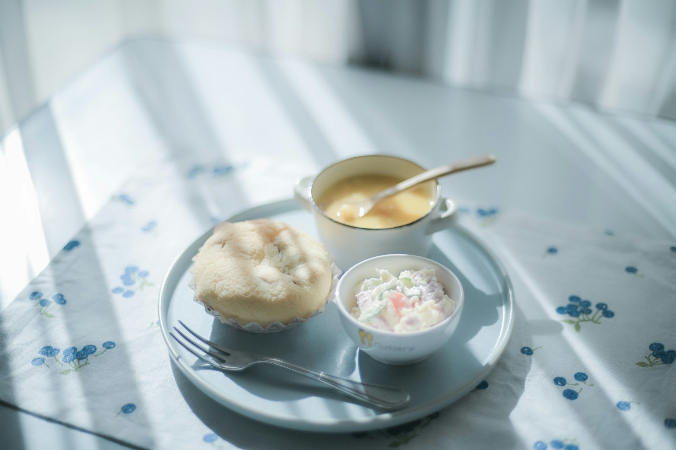 白い皿にパンとスープの朝食