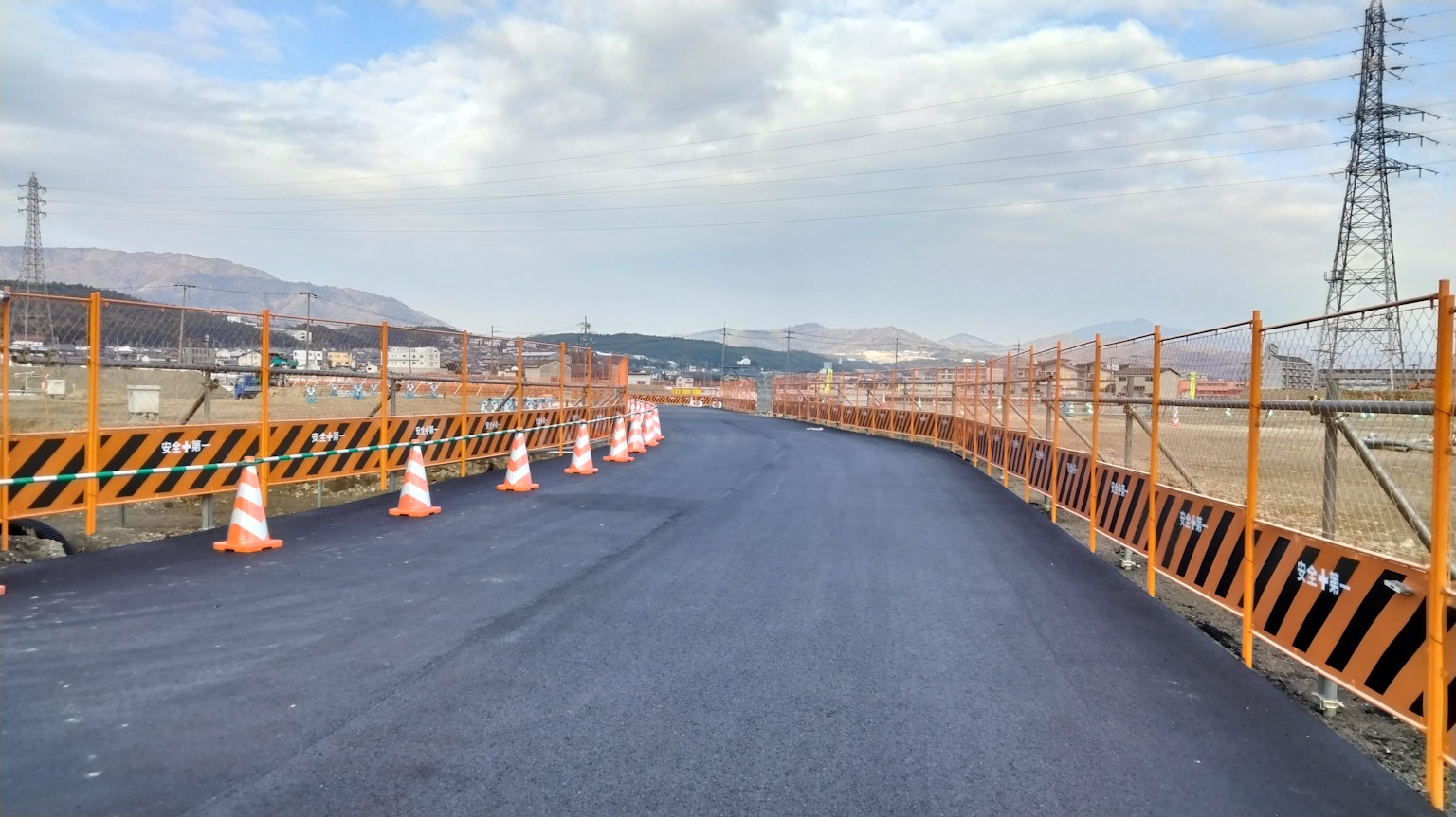 施工現場，展示新鋪設的道路和橙色交通錐