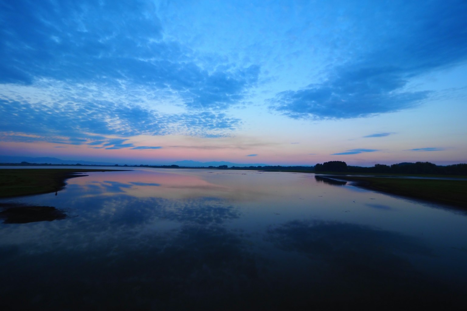 Paesaggio sereno con cielo blu e riflessi del tramonto su acqua calma