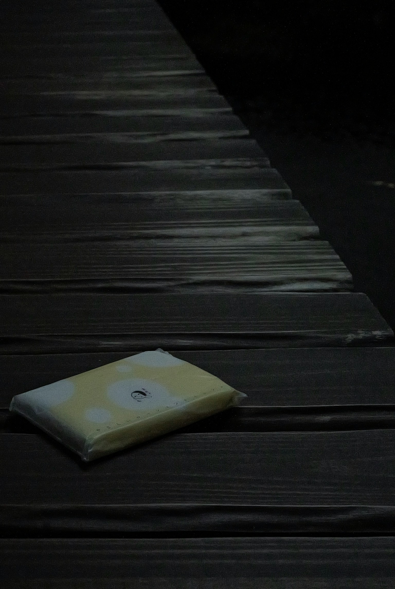 Un paquete amarillo colocado sobre una superficie de madera oscura