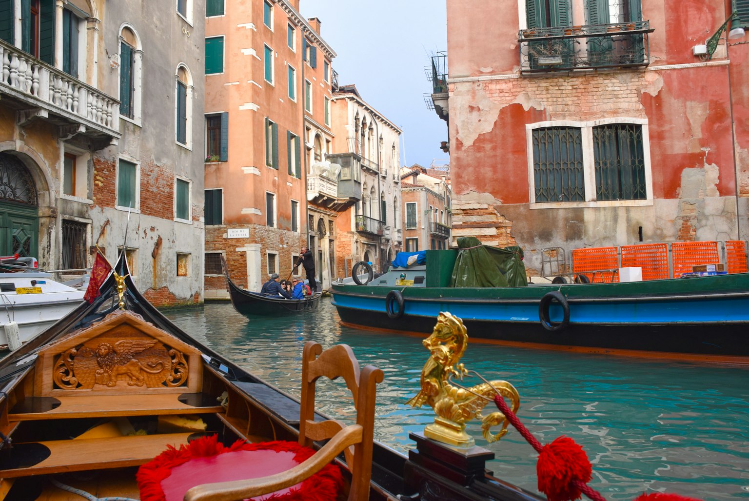 Cảnh kênh Venice từ một chiếc gondola với các tòa nhà đầy màu sắc và thuyền