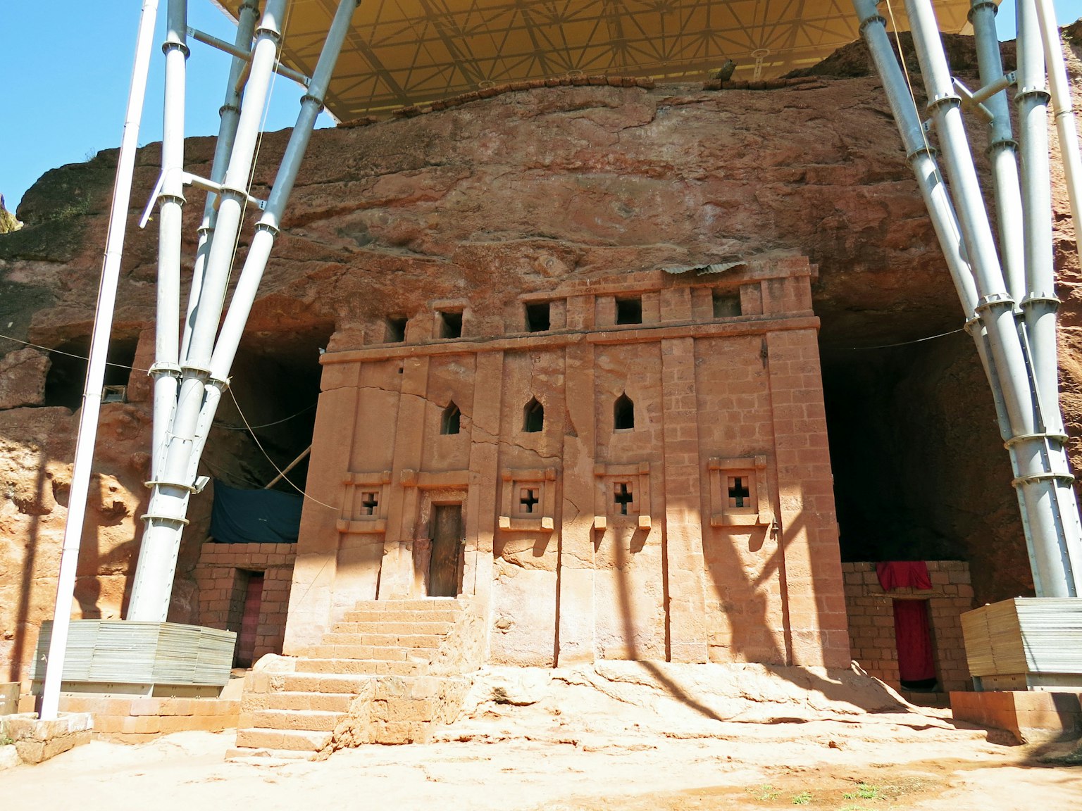 Ancient rock-carved building with supporting structures