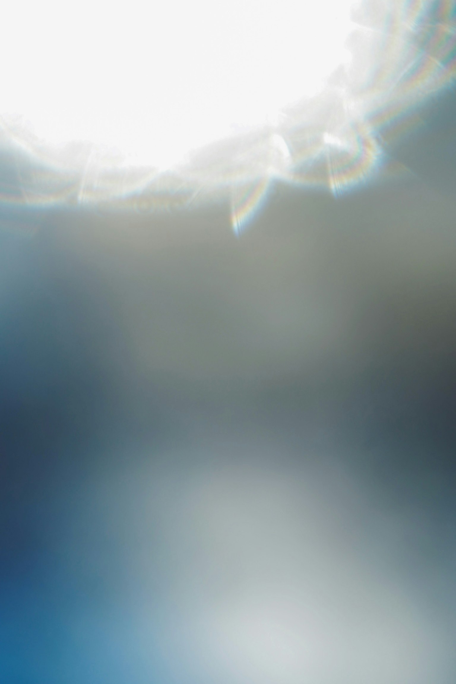 Imagen abstracta con un reflejo de luz brillante sobre un fondo azul difuso
