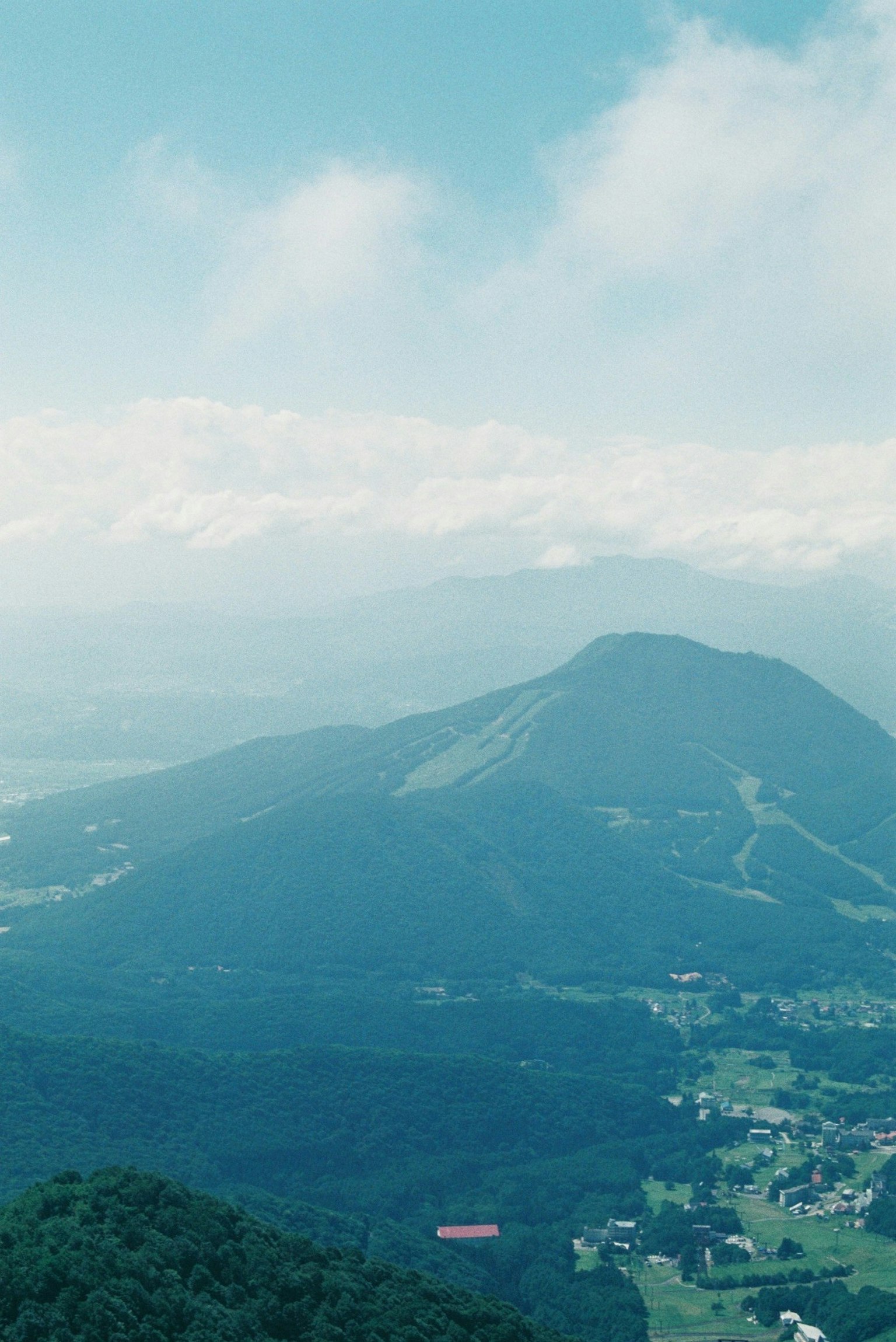 被藍天和雲彩環繞的山景 綠色山丘和山谷延伸