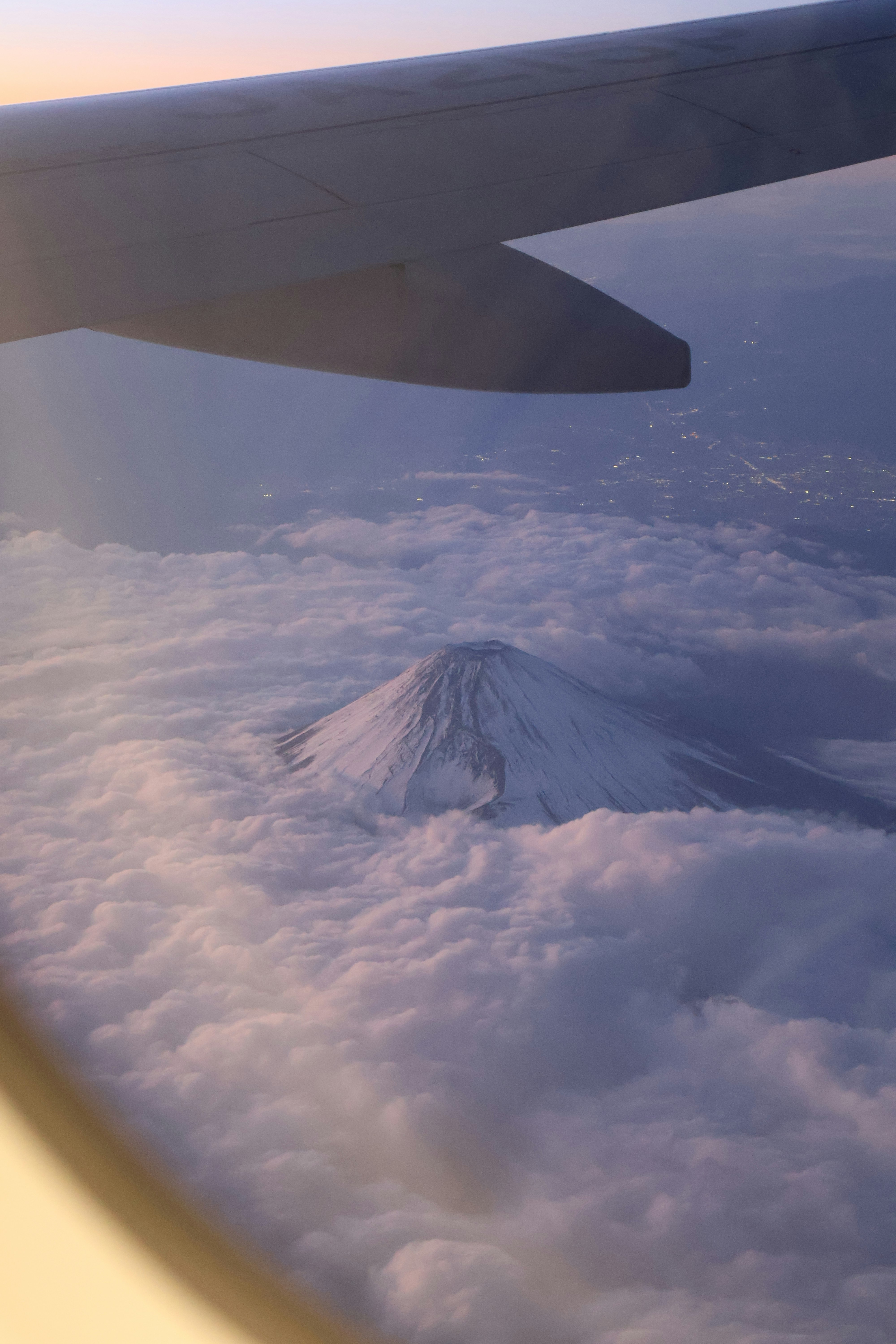 飛行機の窓から見える雲海と富士山のシルエット