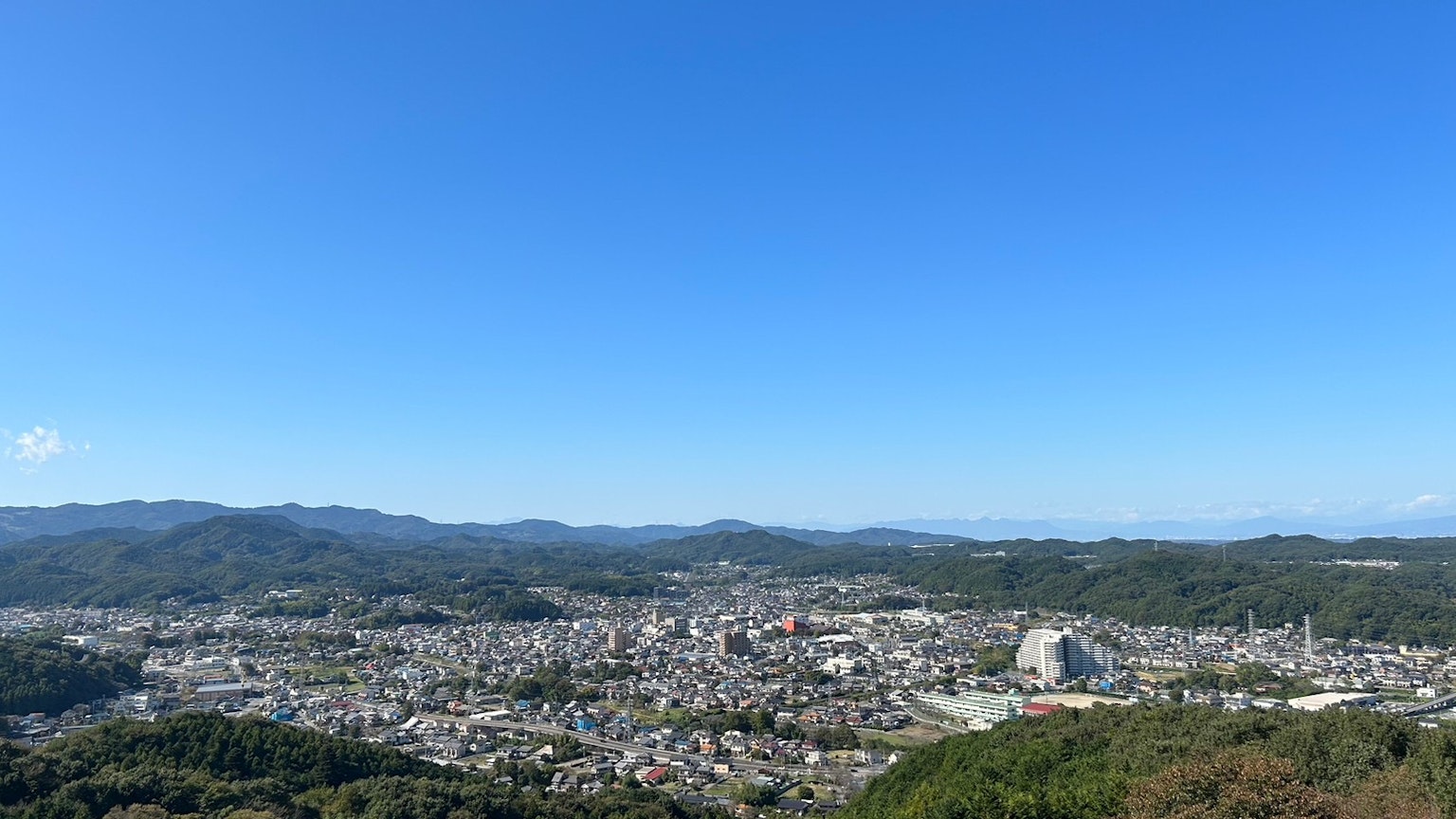 被山脉和晴朗蓝天环绕的城市全景