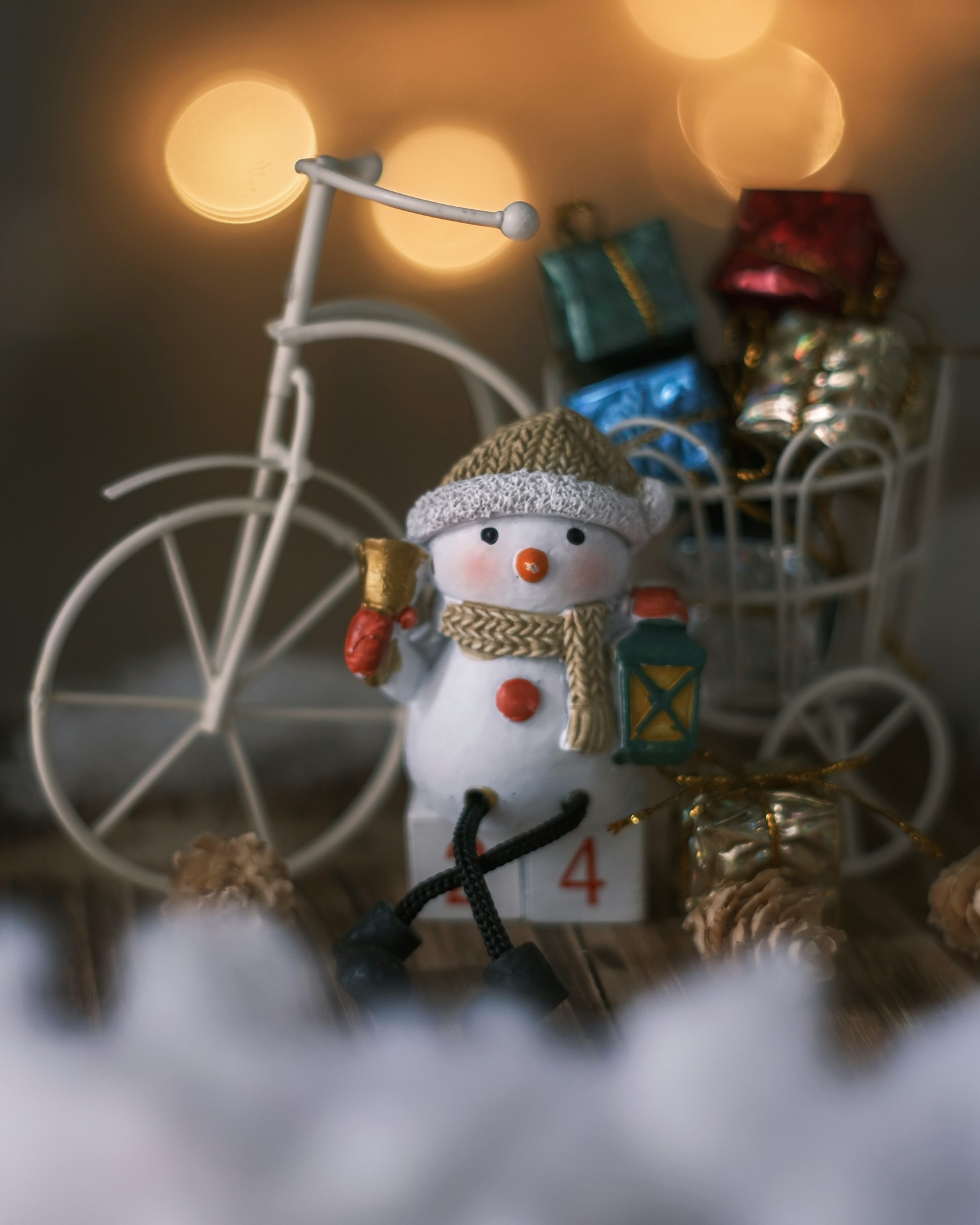 Un pupazzo di neve in piedi davanti a una bicicletta con decorazioni natalizie