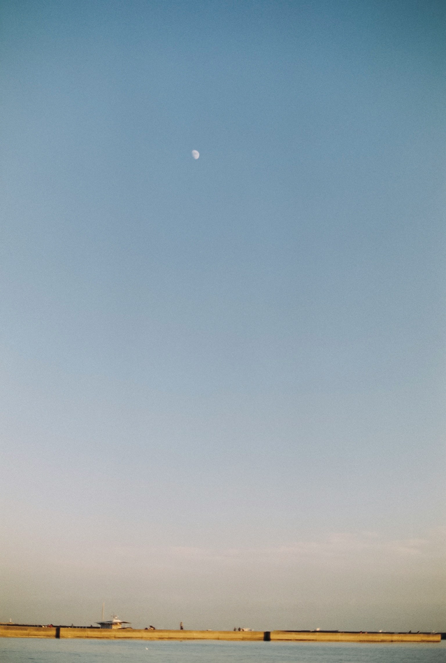Bulan kecil melayang di langit biru yang cerah