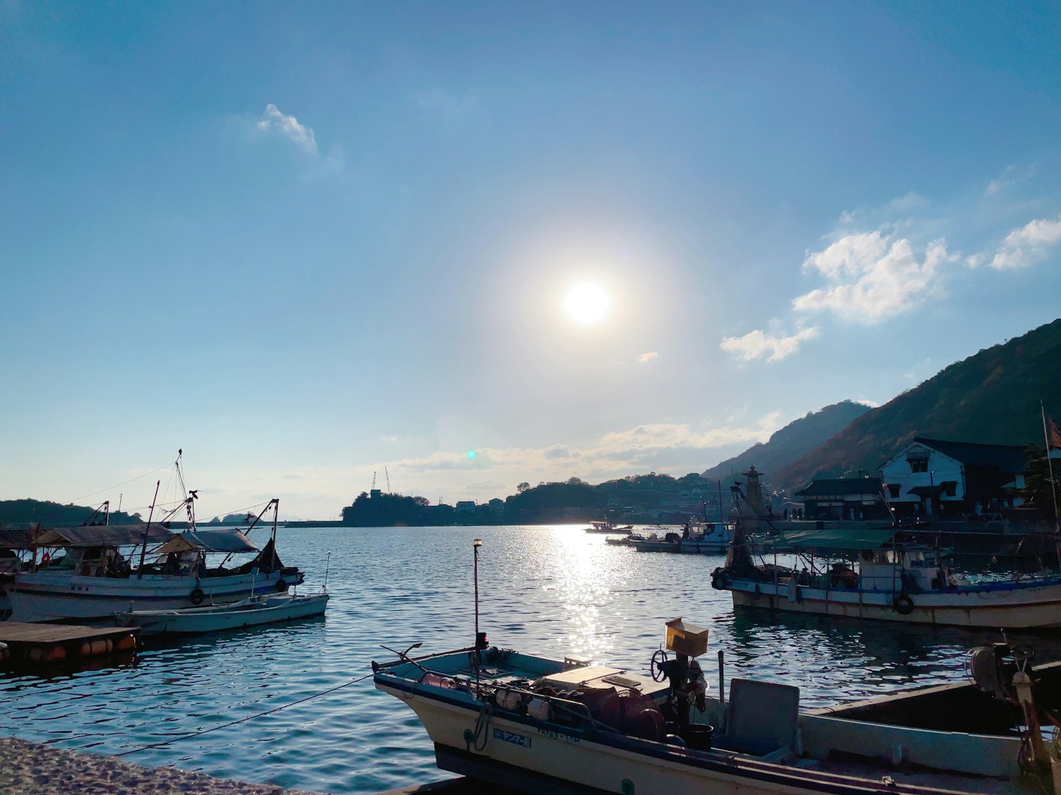 Fishing boats on a calm sea under a bright sun