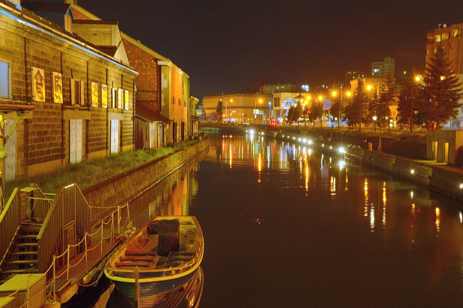 Vista notturna di un canale con edifici illuminati e riflessi