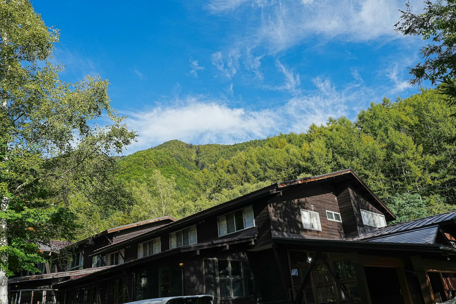 Hébergement en bois entouré de montagnes verdoyantes