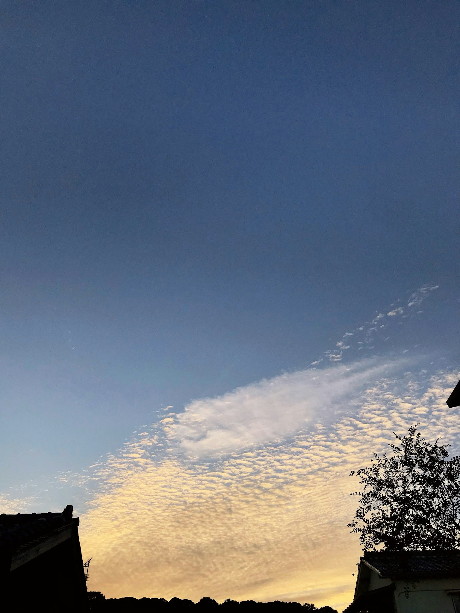 Ciel bleu avec des nuages blancs et des teintes de coucher de soleil
