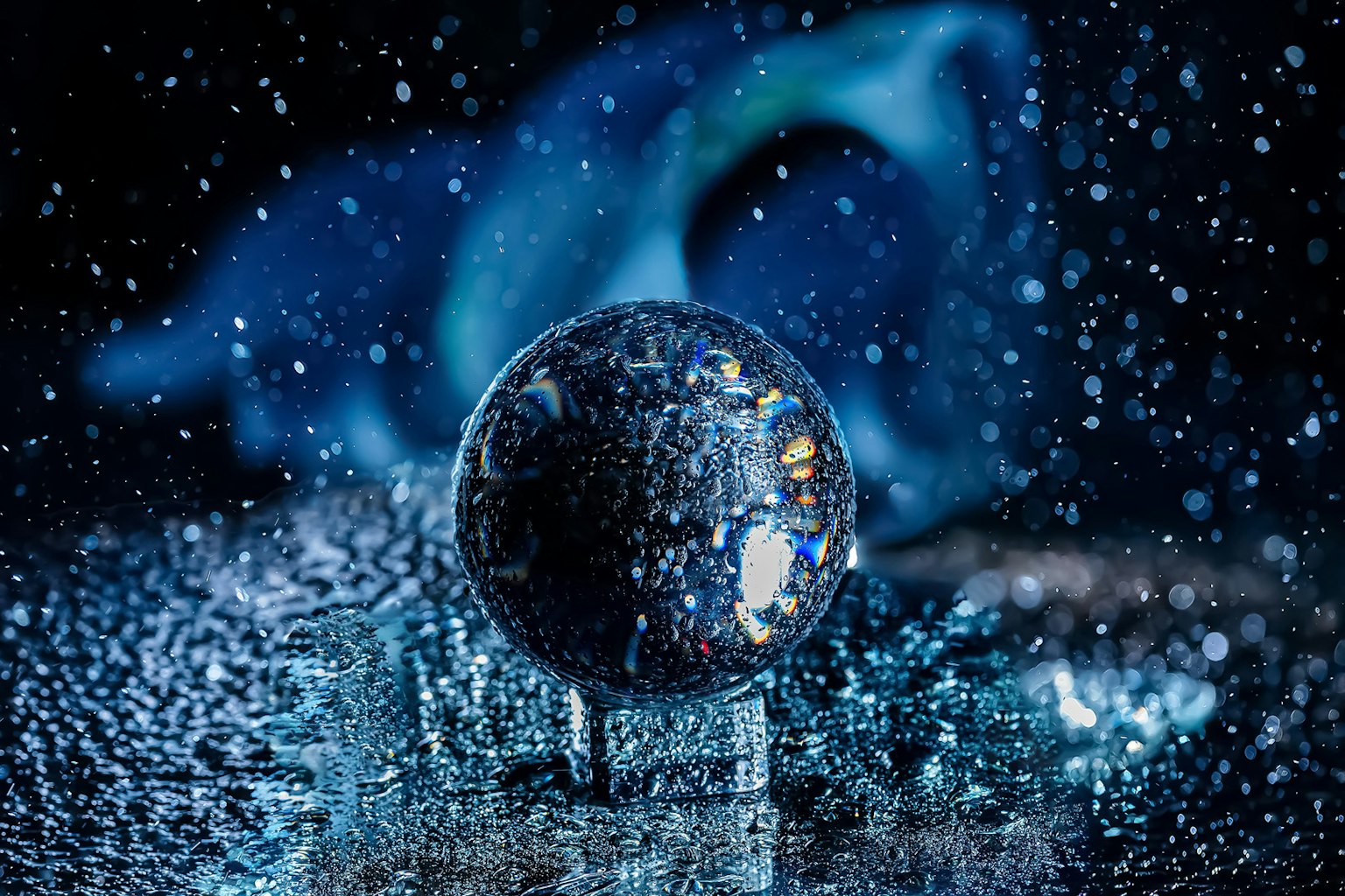 Image d'une boule en cristal entourée de gouttes d'eau éparpillées sur un fond bleu