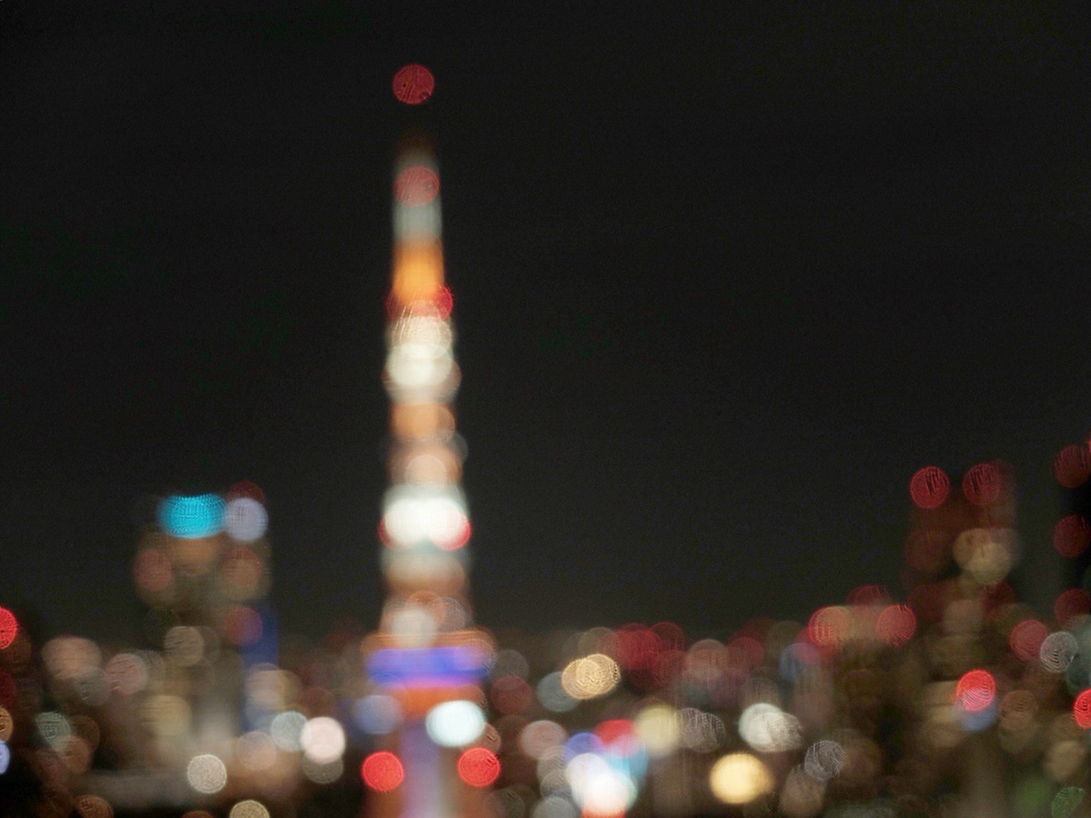Blurred view of Tokyo Tower at night with city lights
