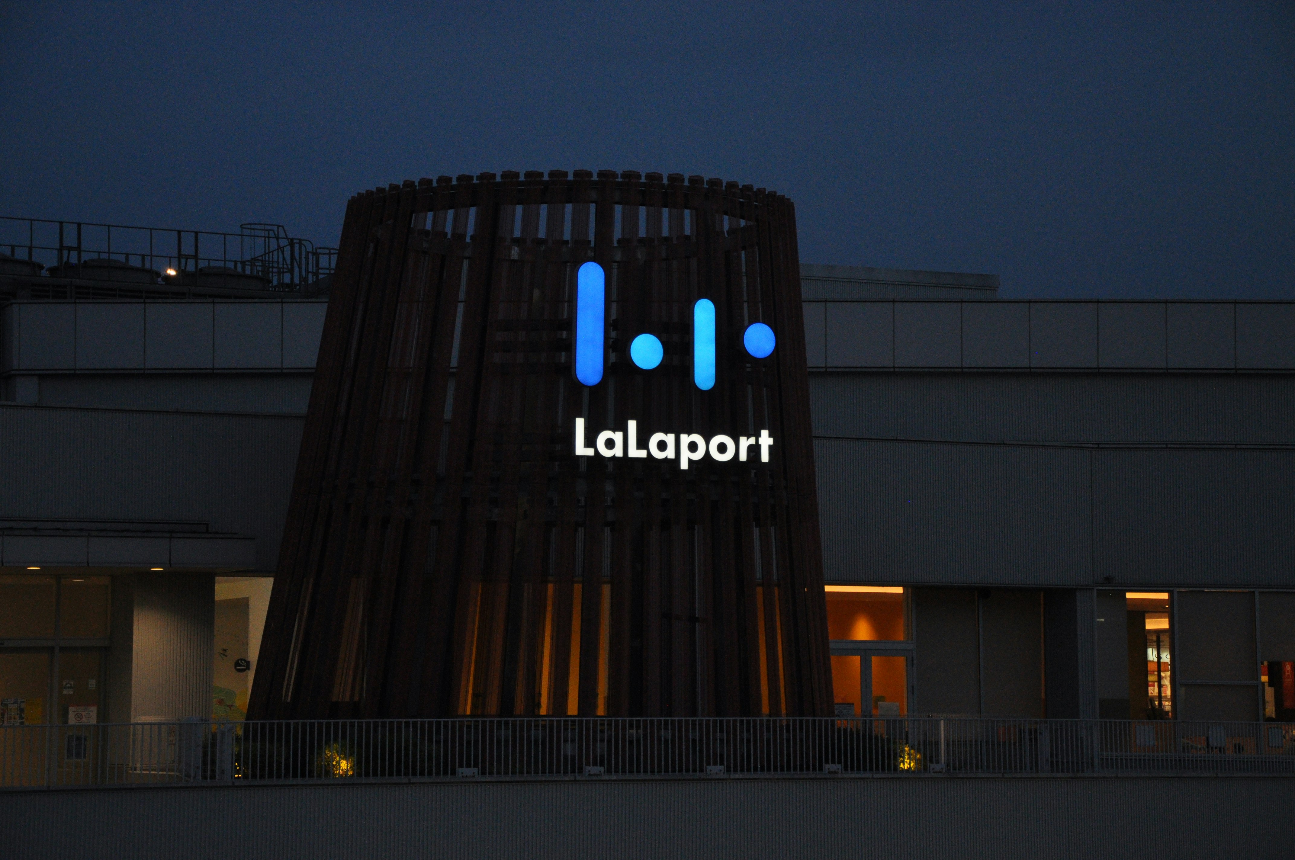 Exterior de un centro comercial de noche con el letrero LaLaport