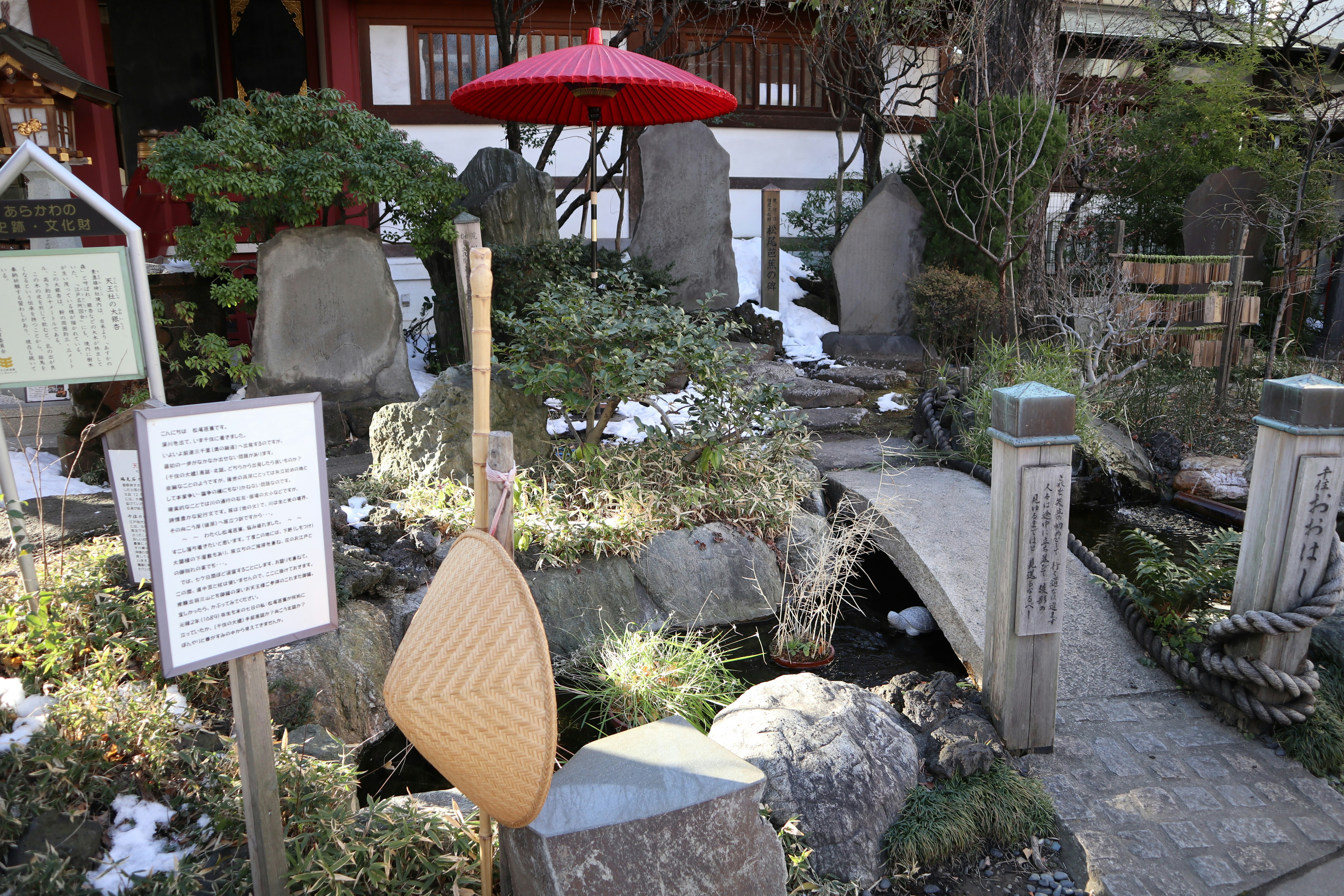 garden path with stones and moss, red umbrella in view