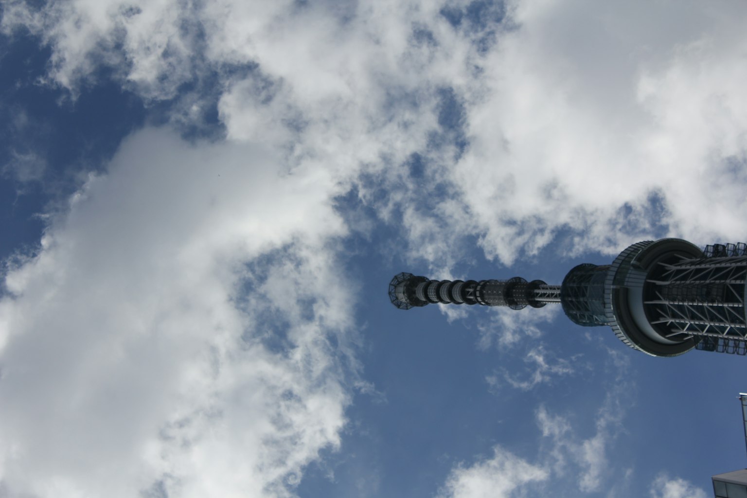 Sommet de la Tokyo Skytree contre un ciel bleu avec des nuages