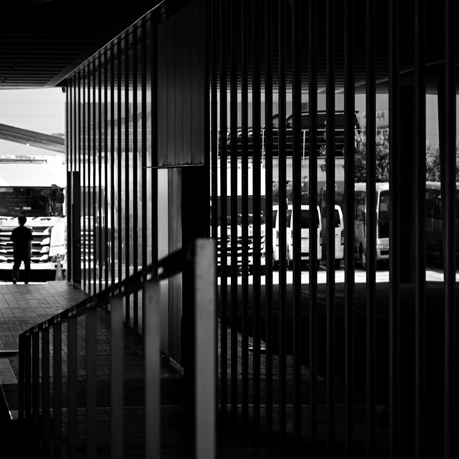 Silueta de una persona dentro de un edificio con estructura de rayas verticales en blanco y negro