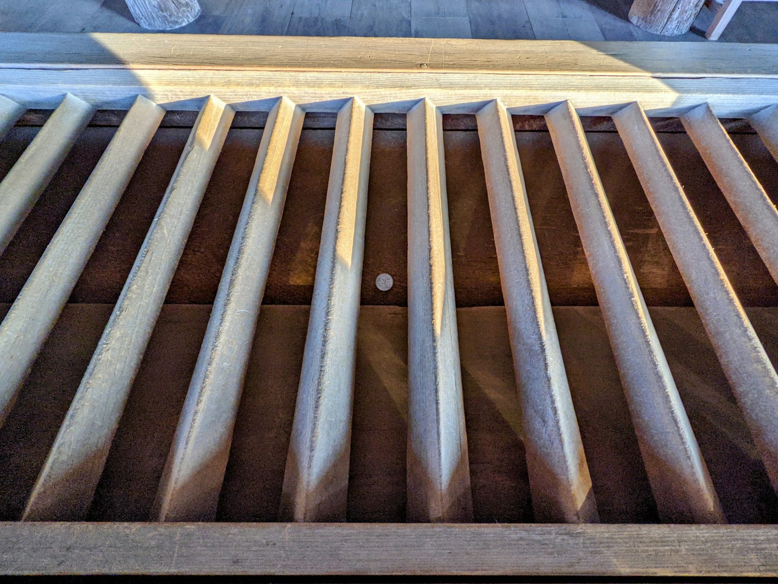 Listelli di legno disposti su un pavimento con una piccola palla bianca