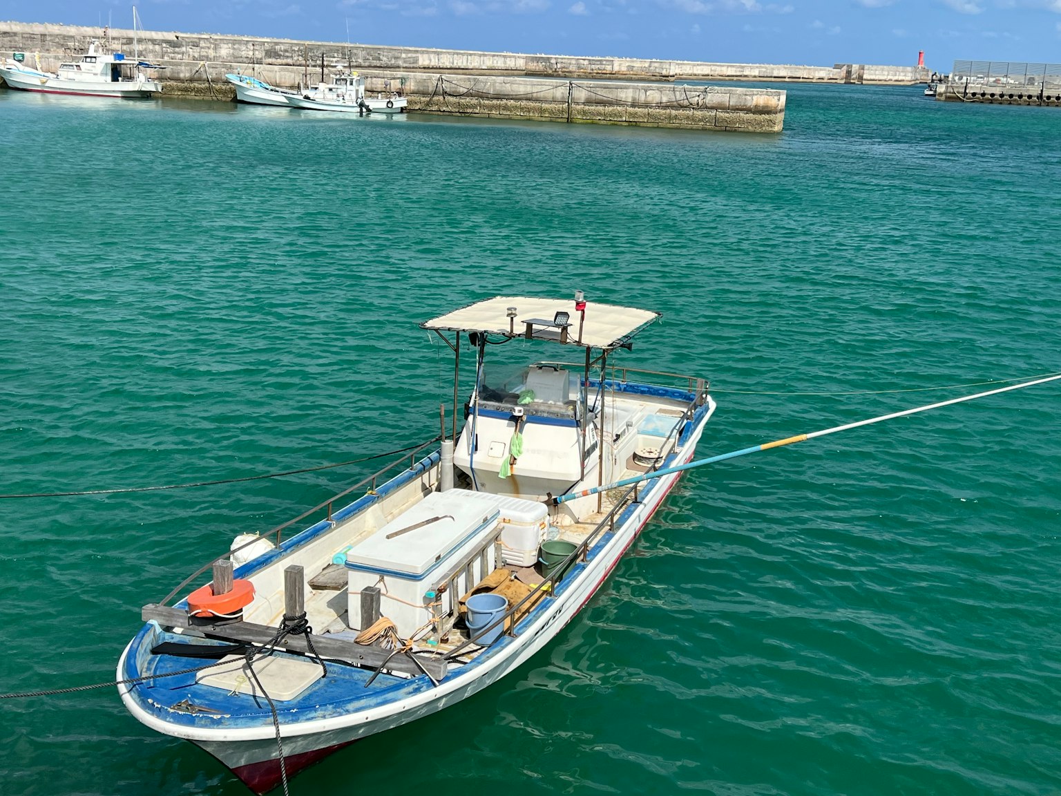 Một chiếc thuyền màu xanh nổi trên mặt nước trong