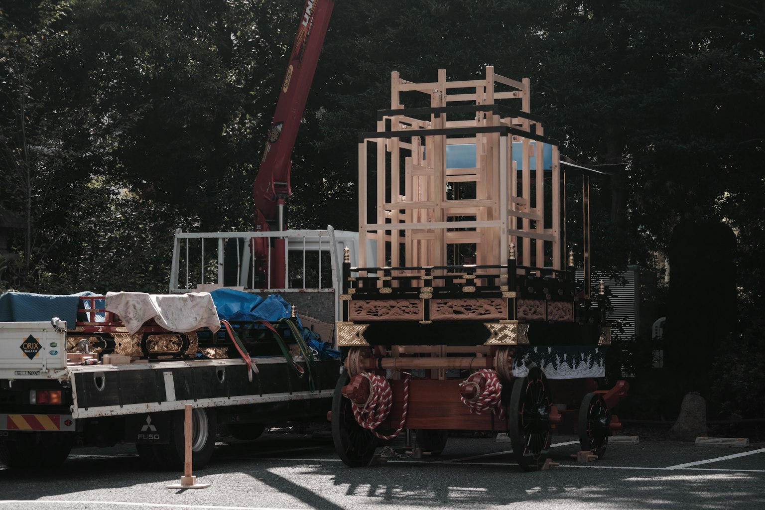 Truk yang mengangkut struktur kayu dengan crane di latar belakang