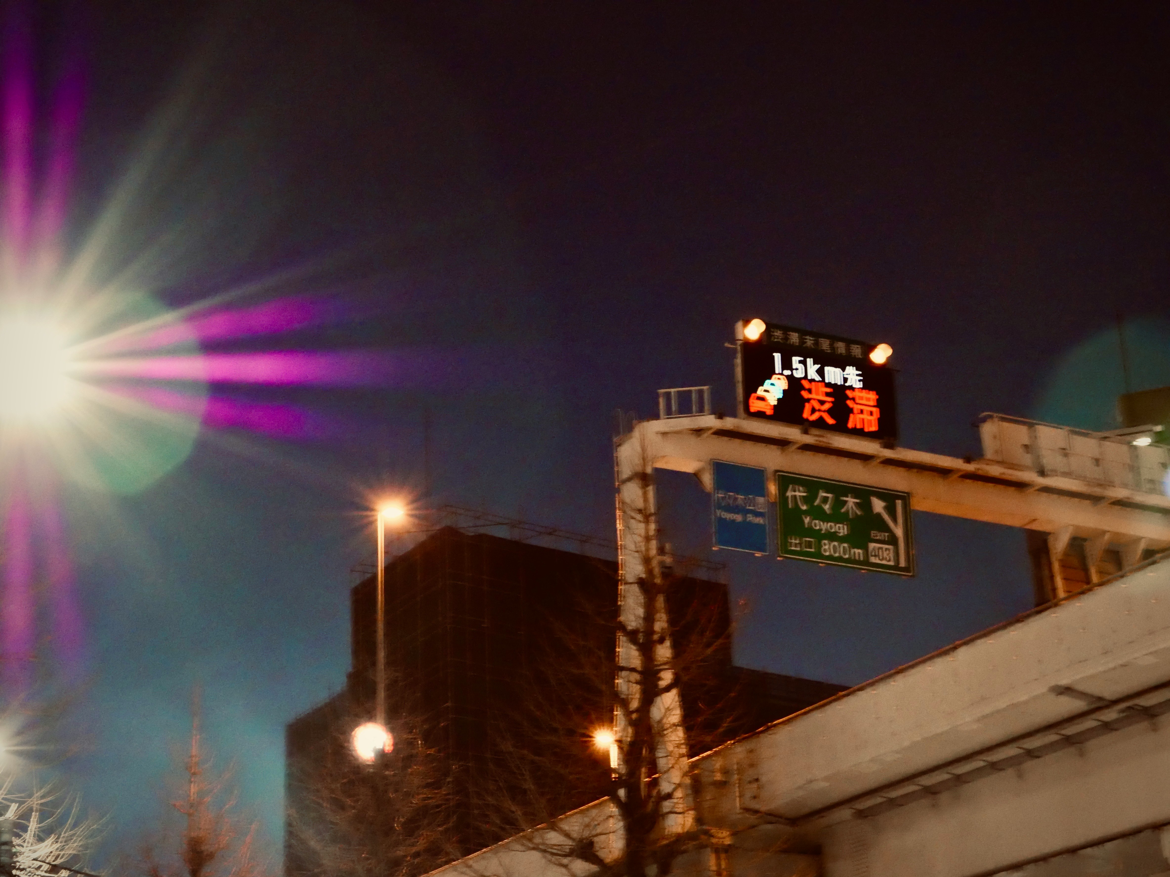 夜の街角に光る看板と建物のある風景