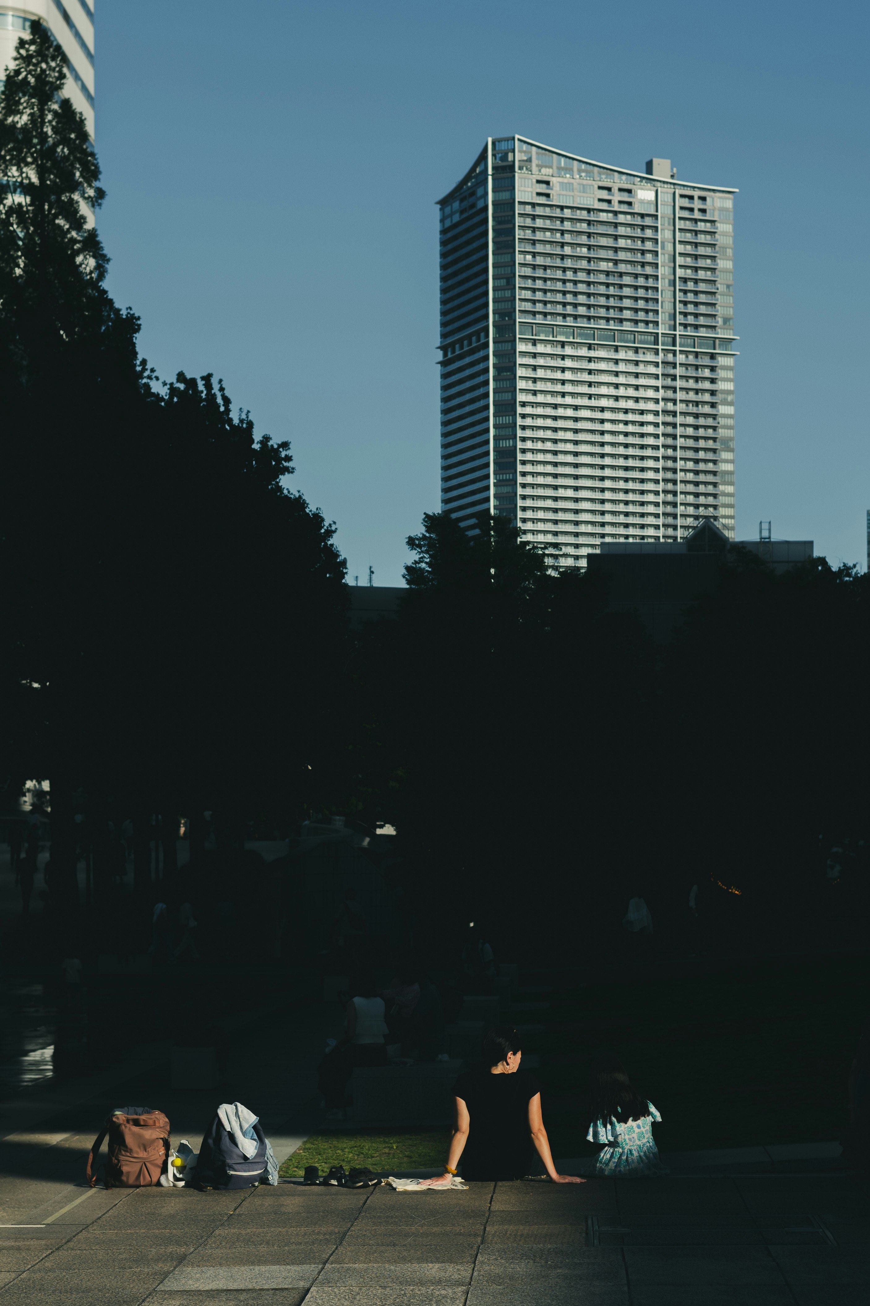 Evening city scene in Yokohama with high-rise buildings and people relaxing in a plaza