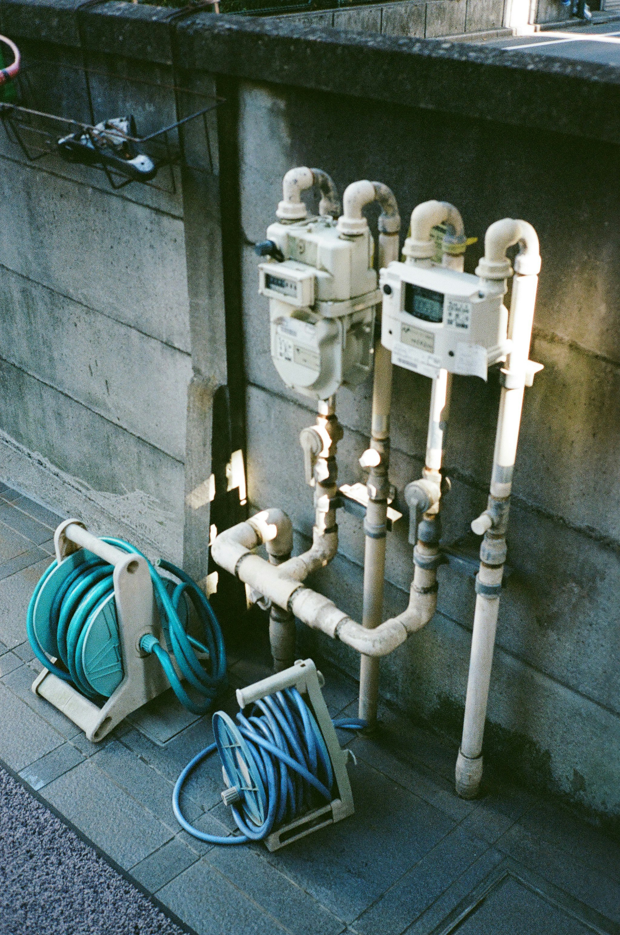 piping and fire hose reels beside a concrete wall