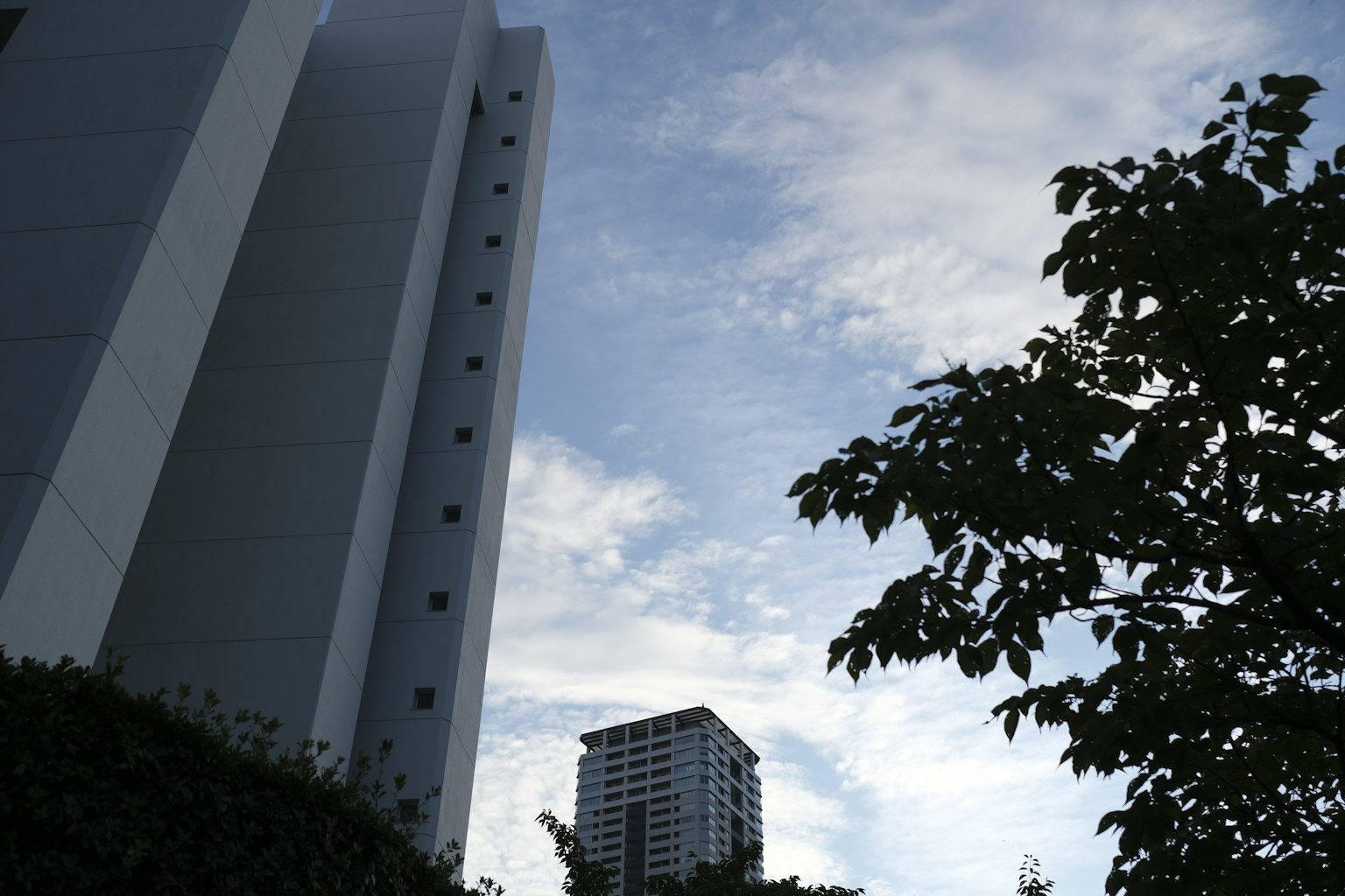 ภาพทิวทัศน์เมืองที่มีตึกสูงและท้องฟ้าสีฟ้า
