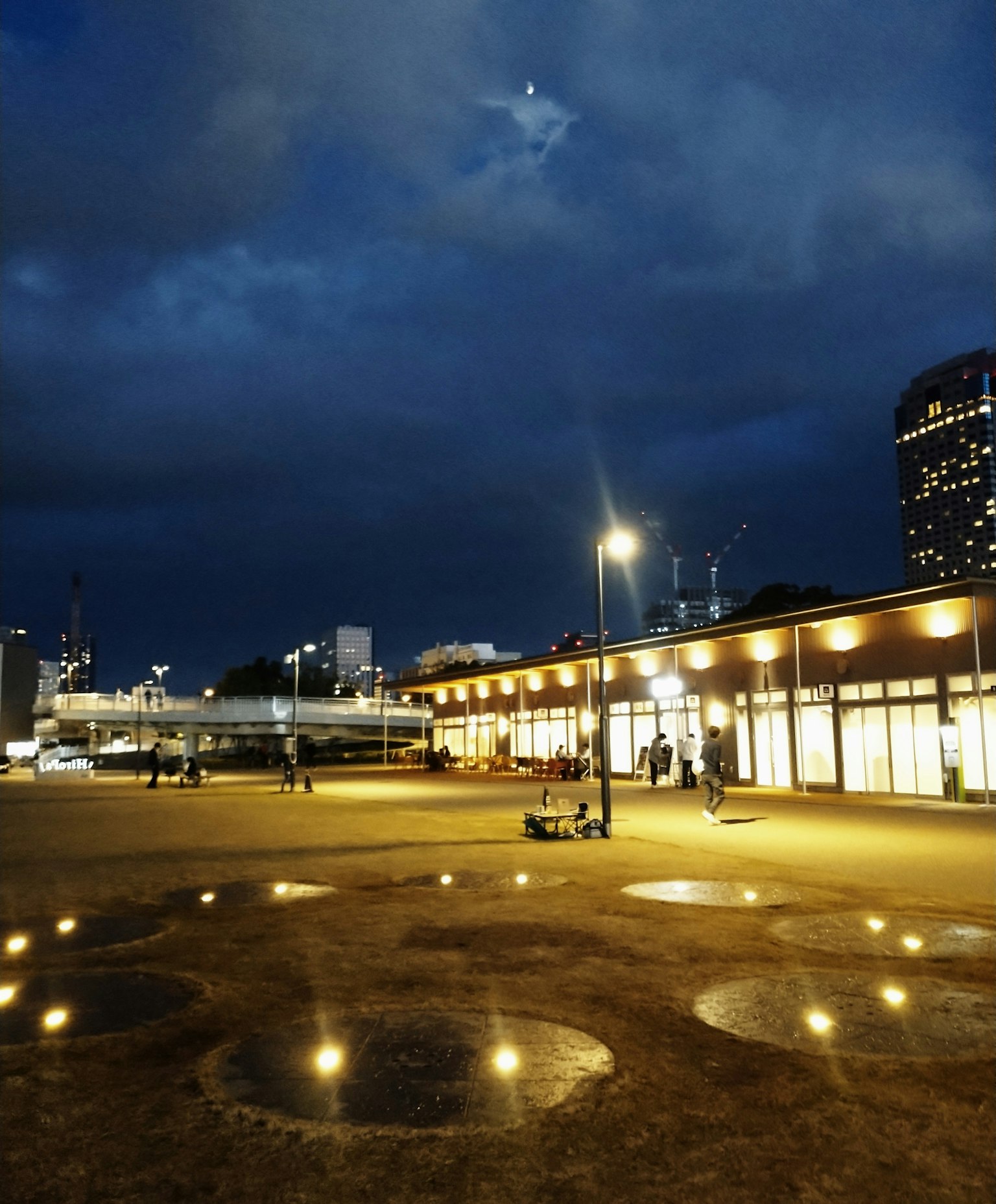Urban night scene with bright lighting and people