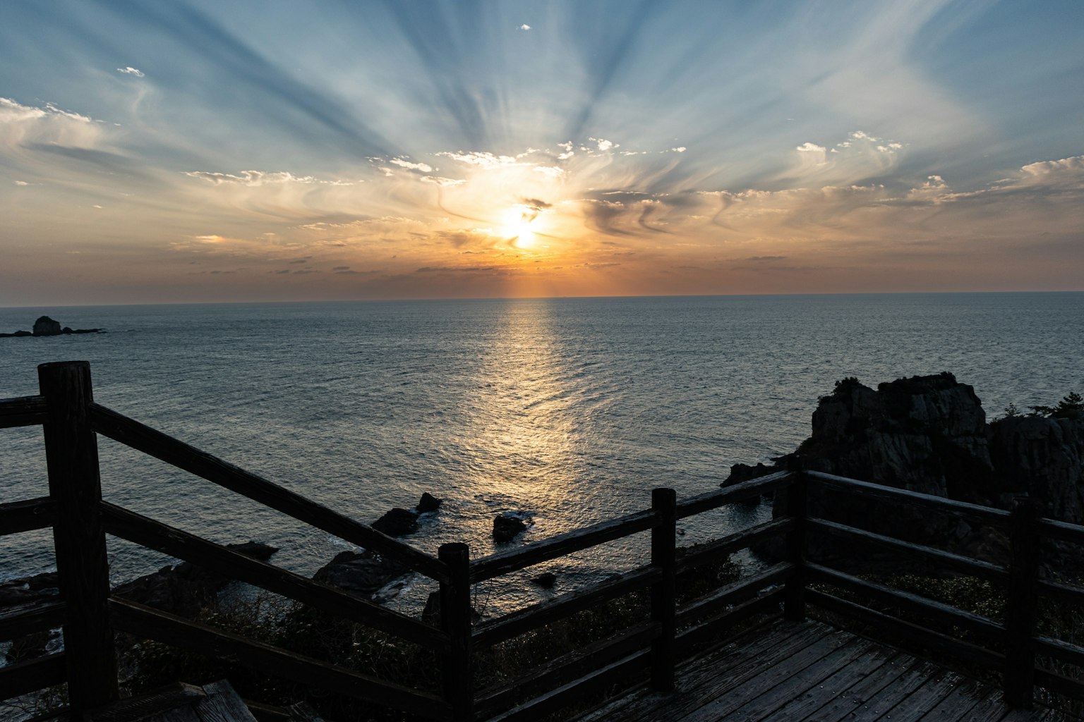 Bellissimo tramonto sull'oceano con parapetto in legno sulla riva