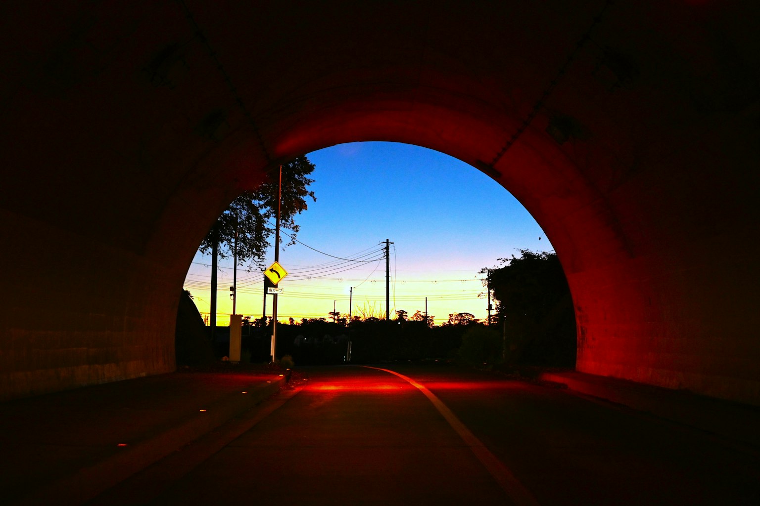 Blick auf den Sonnenuntergangshimmel und die Stadtsilhouette aus dem Tunnel