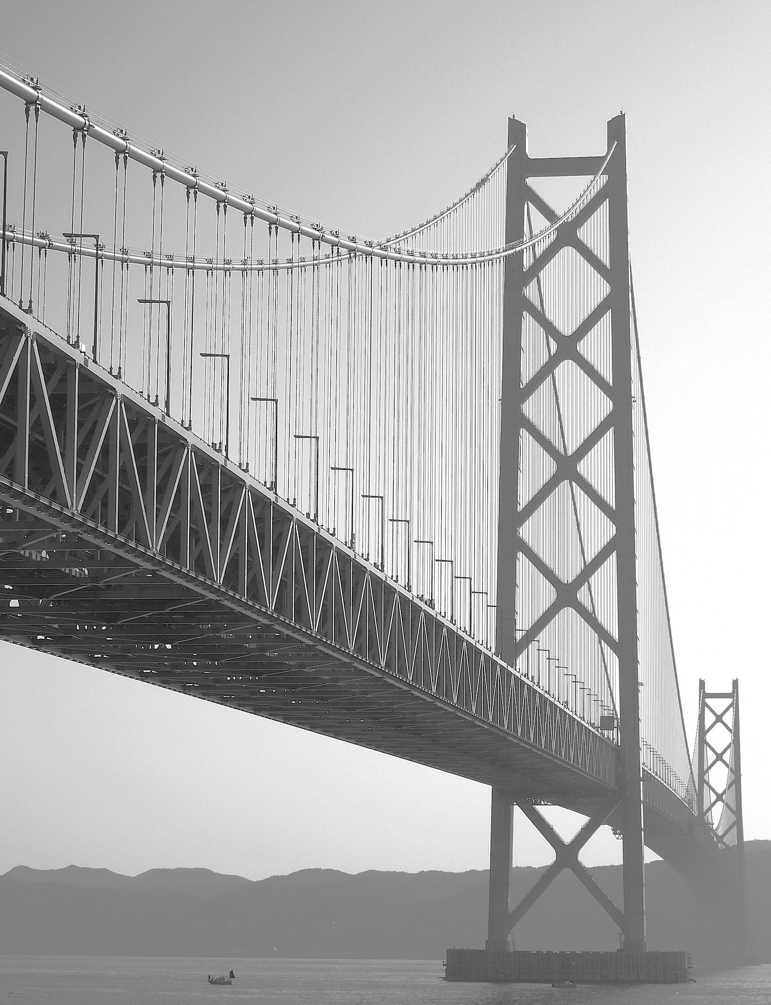 大きな吊り橋の構造が見えるモノクロ写真